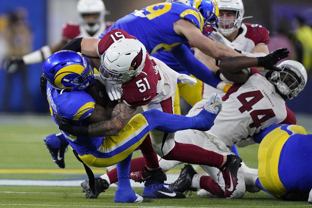El apoyador interno de los Cardinals de Arizona, Tanner Vallejo (51), aborda al corredor de los Rams de Los Ángeles, Cam Akers, durante la primera mitad de un partido de fútbol americano de los playoffs de comodines de la NFL en Inglewood, California, el lunes 17 de enero de 2022. (Foto AP/Marcio Jose Sánchez)