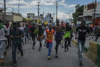 Manifestantes que exigían la renuncia del primer ministro de Haití, Ariel Henry, corren después de que la policía les lanzara gas lacrimógeno para dispersarlos en el sector de Delmas, en Puerto Príncipe, el lunes 10 de octubre de 2022. (AP Foto/Odelyn Joseph)