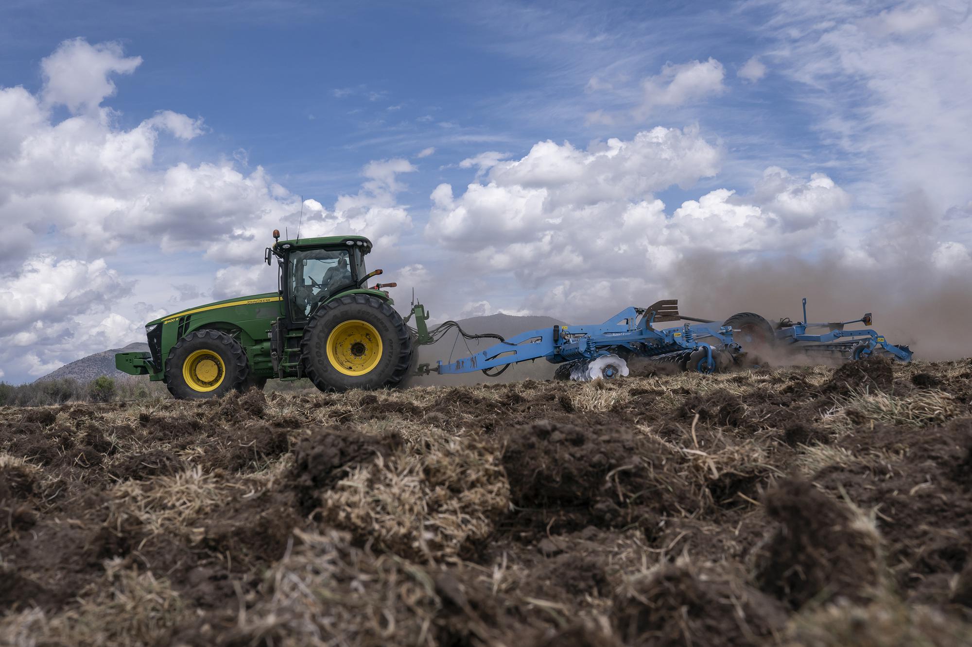 A tractor tears dried dirt on land that was unplanted this year due to the water shortage on Wednesday, June 9, 2021, in Tulelake, Calif. This summer for the first time ever, hundreds of farmers along the California-Oregon border who rely on irrigation from a depleted, federally managed lake aren't getting any water from it at all. Competition over the water in the Klamath Basin has always been intense, but this summer, because of a historic drought there is not enough water for the needs of farmers, Native American tribes and wildlife refuges. (AP Photo/Nathan Howard)