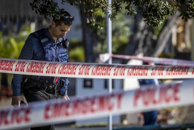 La policía levantar un cordón policial y registra una zona de un suburbio de Auckland donde se reportaron múltiples apuñalamientos, en Nueva Zelanda, el 23 de junio de 2022. (Michael Craig/New Zealand Herald via AP)