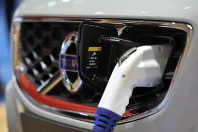 ARCHIVO - Un cargador conectado a un automóvil eléctrico durante el Motor Show de Ginebra, Suiza, el miércoles 2 de marzo de 2011. (AP Foto/Keystone, Martial Trezzini, Archivo)