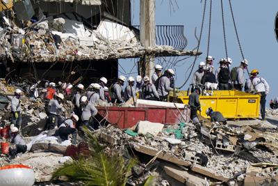 Rescatistas buscan entre los escombros del condominio Champlain Towers South, el lunes 28 de junio de 2021, en Surfside, Florida. (AP Foto/Lynne Sladky)