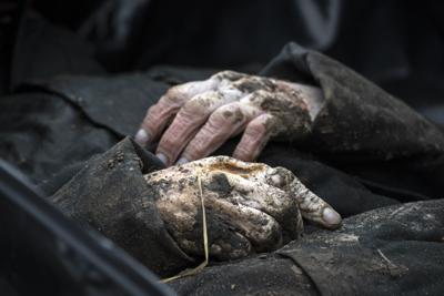 ARCHIVO - Vista del cadáver de un civil trasportado a la morgue en Bucha, afueras de Kiev, Ucrania, 6 de abril de 2022. Dos exministros alemanes han iniciado una demanda penal para que se investigue a funcionarios rusos por crímenes de guerra en Ucrania. (AP Foto/Rodrigo Abd,file)