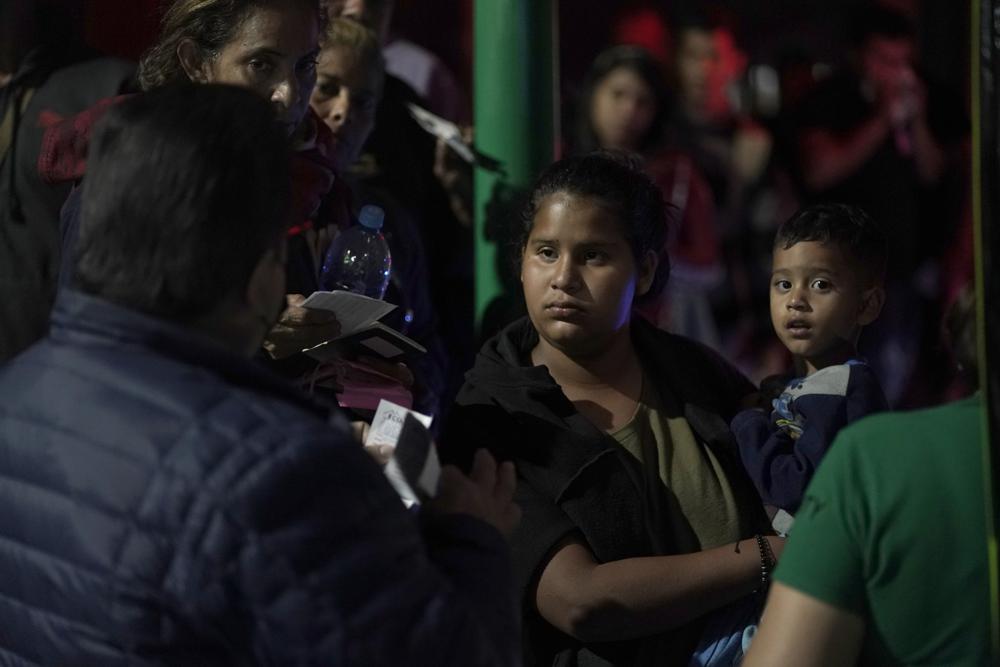 Un empleado de una compañía de buses comprueba los permisos de migrantes venezolanos antes de dejarlos subir a un bus que los lleve hacia la frontera, en la estación de autobuses del norte, en la Ciudad de México, el 13 de octubre de 2022. Washington anunció en la víspera que los venezolanos que crucen su frontera nadando o a pie serán devueltos inmediatamente a México y no tendrán derecho a solicitar asilo. (AP Foto/Eduardo Verdugo)