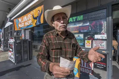 Roberto Ramírez, de 77 años y nativo de Guadalajara, México, muestra un boleto de SuperLotto Plus en la gasolinera que anteriormente vendió el boleto ganador del premio de la lotería Powerball de 2.040 millones de dólares en Joe's Service Center, una gasolinera de Mobil en Altadena, California, el viernes, 6 de enero de 2023. (AP Foto/Damian Dovarganes)