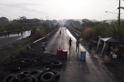 Una barricada colocada por personas que protestan contra la inflación, especialmente el aumento de los precios del combustible, obliga a la gente a caminar en Pacora, Panamá, la madrugada del miércoles 20 de julio de 2022. (Foto AP/Arnulfo Franco)