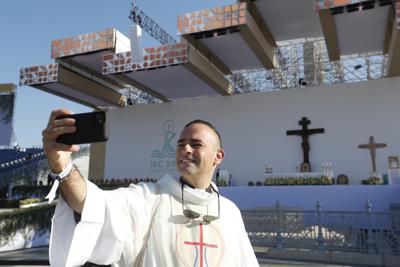 Un sacerdote se toma una foto con el altar de fondo donde el papa Francisco ofreció una misa por la clausura del Congreso Eucarístico Internacional, en la Plaza de los Héroes de Budapest, el domingo 12 de septiembre de 2021. (Foto AP/Laszlo Balogh)