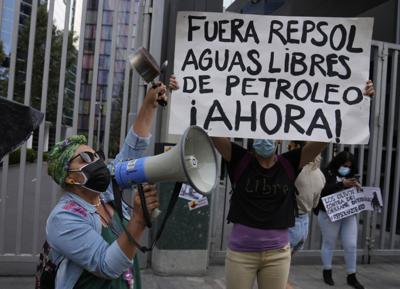 Manifestante sostiene una pancarta que dice en español "Fuera Repsol aguas libres de petróleo Ahora!" durante una protesta frente a la oficina de Repsol en Lima, Perú, el jueves 27 de enero de 2022. Los manifestantes llegaron hasta allí para protestar después de que Perú declaró una emergencia ambiental luego de anunciar que 21 playas en la costa del Pacífico estaban contaminadas por un derrame de petróleo en una refinería administrada por Repsol, con sede en España, luego de oleajes provocados por la erupción de un volcán submarino cerca de Tonga. (Foto AP/Martín Mejía)