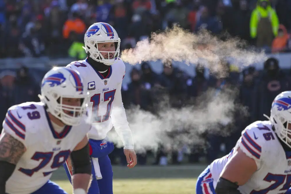 Buffalo Bills quarterback Josh Allen (17) and tackle Spencer Brown (79) exhale before a successful two-point attempt in the second half of an NFL football game against the Chicago Bears in Chicago, Saturday, Dec. 24, 2022. (AP Photo/Charles Rex Arbogast)