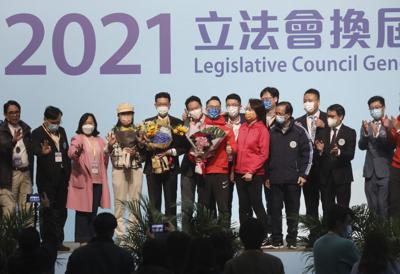 El candidato pro Beijing Ng Chau-pei, quinto de izquierda a derecha, festeja con otros candidatos electos que también son partidarios del gobierno chino tras ganar los comicios legislativos el lunes 20 de diciembre de 2021, en Hong Kong. (AP Foto)