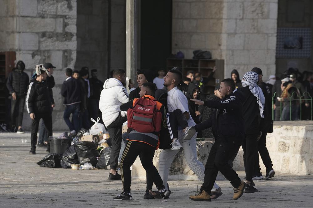 Un manifestante palestino herido en enfrentamientos con la policía israelí es llevado a un lugar seguro en el complejo de la Mezquita de Al Aqsa en la Ciudad Vieja de Jerusalén, el viernes 22 de abril de 2022. La policía israelí y los jóvenes palestinos se enfrentaron nuevamente en el principal lugar sagrado de Jerusalén, sagrado para judíos y musulmanes, el viernes 22 de abril de 2022. el viernes a pesar de la interrupción temporal de las visitas judías al sitio, que los palestinos consideran una provocación.  (Foto AP/Mahmoud Illean)