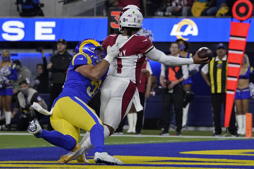 El linebacker interno de los Rams de Los Ángeles, Troy Reeder, a la izquierda, presiona al mariscal de campo de los Cardinals de Arizona, Kyler Murray (1), para que lance un pase que fue interceptado y devuelto para touchdown por David Long Jr. durante la primera mitad de un partido de fútbol americano de los playoffs de comodines de la NFL en Inglewood, California, lunes 17 de enero de 2022. (Foto AP/Mark J. Terrill)