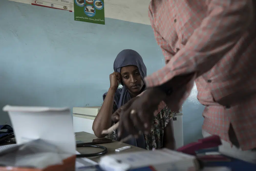 FILE - Surgeon and doctor-turned-refugee, Dr. Tewodros Tefera, prepares a malaria test for 23-year-old Tigrayan refugee Hareg from Mekele, Ethiopia, at the Sudanese Red Crescent clinic in Hamdayet, eastern Sudan, near the border with Ethiopia, on March 17, 2021. The coronavirus pandemic interrupted efforts to control malaria, resulting in 63,000 more deaths and 13 million more infections. That's according to a World Health Organization report released Thursday Dec. 8, 2022. (AP Photo/Nariman El-Mofty, File)