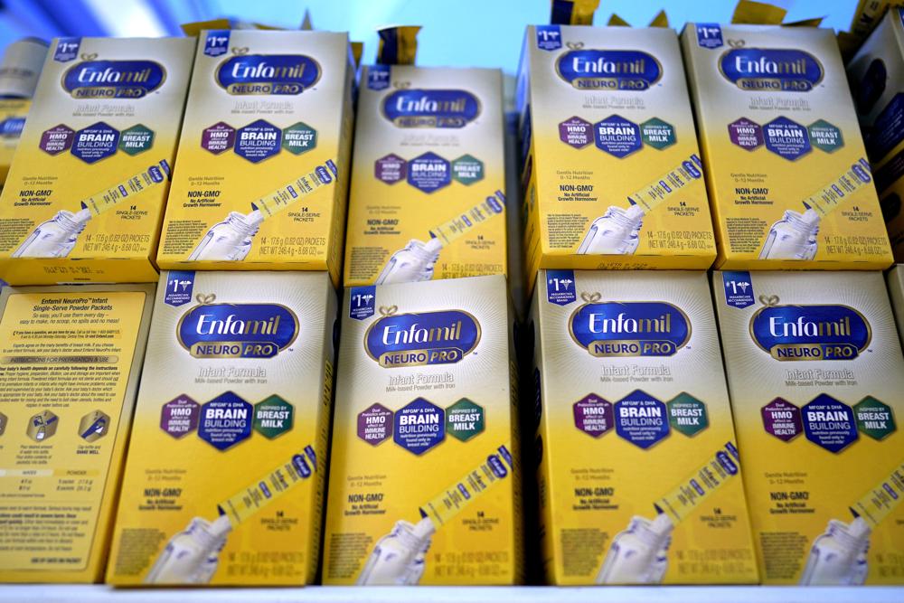 FILE - Infant formula is stacked on a table during a baby formula drive to help with the shortage May 14, 2022, in Houston.  President Joe Biden has invoked the Defense Production Act to speed production of infant formula and has authorized flights to import supply from overseas. (AP Photo/David J. Phillip, File)