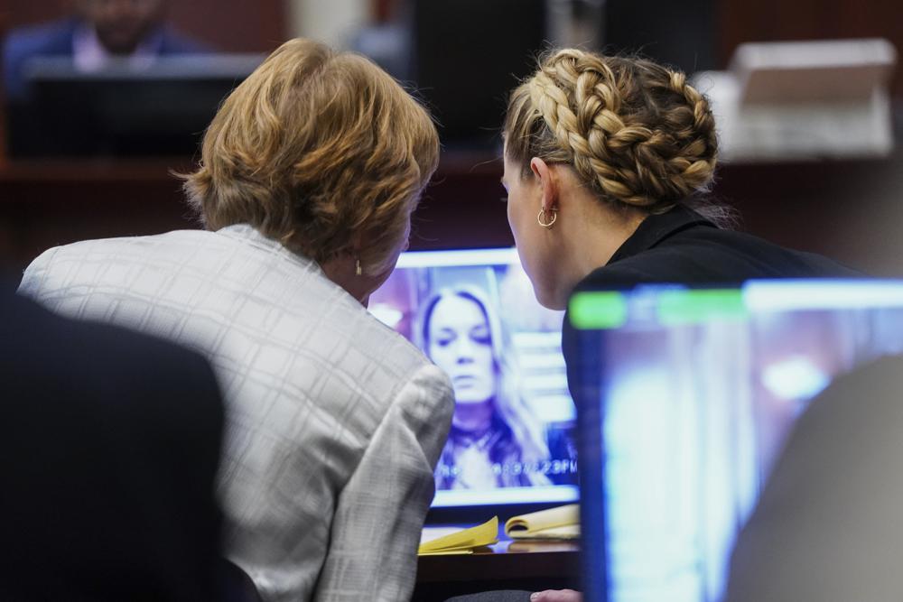 La actriz Amber Heard, a la derecha, y la abogada Elaine Bredehoft, miran el testimonio en video de la ex asistente personal de Heard, Kate James, en el juzgado de circuito del condado de Fairfax en Fairfax, Virginia, el jueves 14 de abril de 2022. El actor Johnny Depp demandó a su ex esposa Amber Heard por difamación en el Tribunal de Circuito del Condado de Fairfax después de que escribió un artículo de opinión en The Washington Post en 2018 refiriéndose a sí misma como una "figura pública que representa el abuso doméstico".  (Foto de Shawn Thew/Pool vía AP)