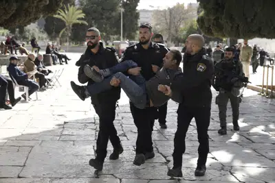 La policía israelí detiene a un palestino en el complejo de la mezquita de Al-Aqsa tras una redada en el lugar sagrado de la Ciudad Vieja de Jerusalén, durante el mes sagrado del Ramadán, el 5 de abril de 2023. (AP Foto/Mahmoud Illean)