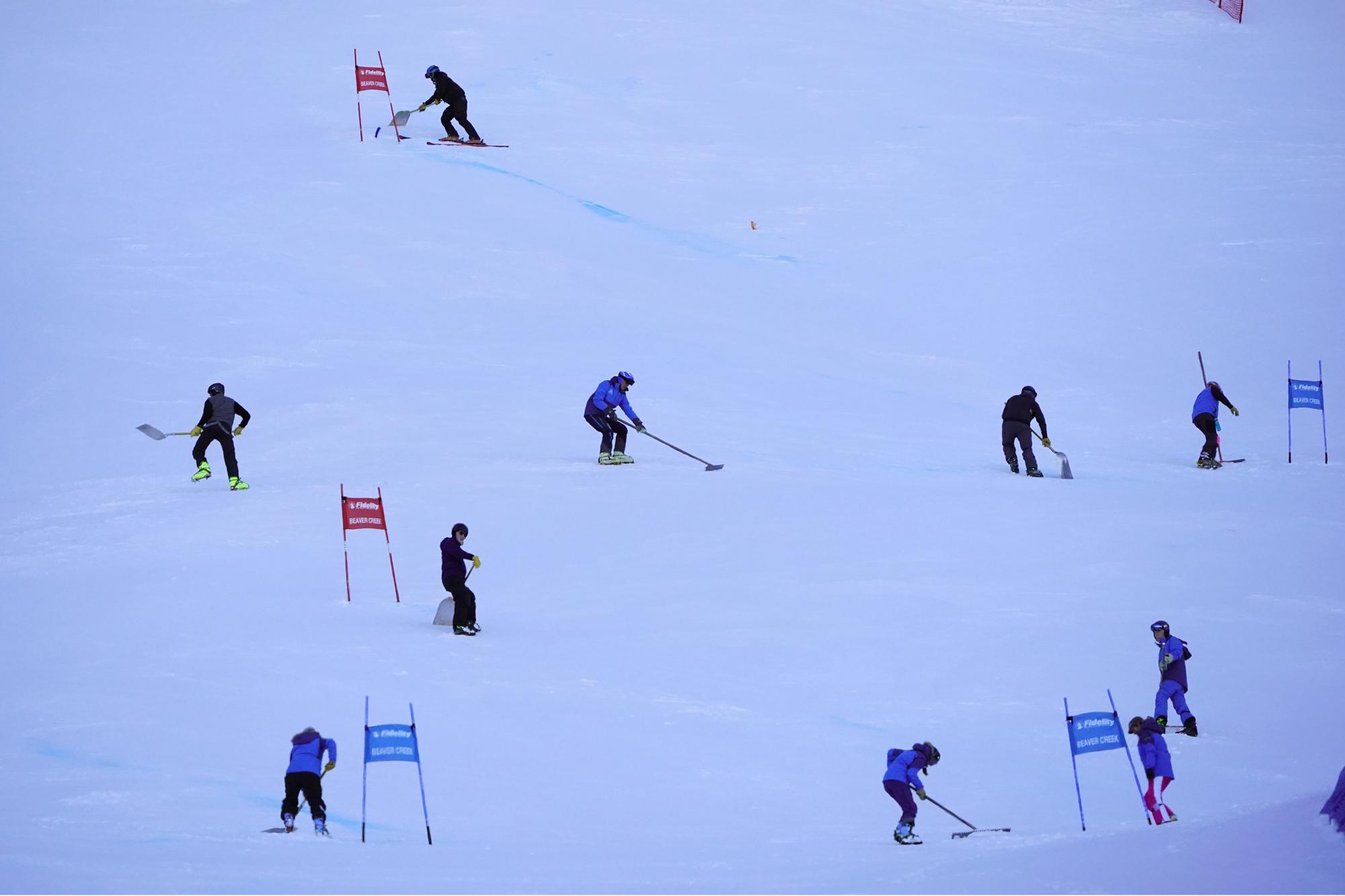FILE - Course workers groom man-made snow before the start of a World Cup Super-G race on Dec. 2, 2021. Olympic athletes in Alpine skiing and other outdoor sports dependent on snow are worried as they see winters disappearing. (AP Photo/Robert F. Bukaty, File)