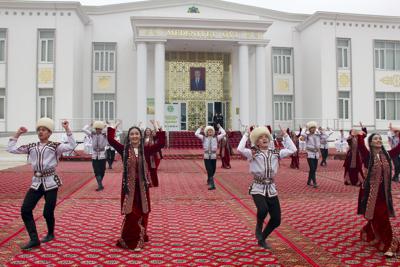 Artistas vestidos con trajes nacionales turcomanos bailan frente a un centro de votación durante las elecciones presidenciales en Ashgabat, Turkmenistán, el sábado 12 de marzo de 2022. Los ciudadanos de Turkmenistán han votado en una elección que podría establecer una dinastía política para el líder de la nación de Asia Central, rica en gas. El presidente Gurbanguly Berdymukhamedov, de 64 años, anunció las elecciones presidenciales anticipadas el mes pasado, preparando el escenario para que su hijo Serdar, de 40 años, asumiera el cargo. (AP Foto/Alexander Vershinin)