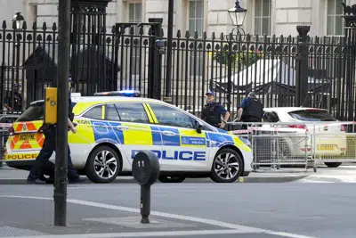 La policía acude al lugar donde un auto chocó con los portones de Downing Street, Londres, jueves 25 de mayo de 2023. La residencia y oficinas del primer ministro se encuentran en esa calle. Un hombre fue arrestado, dijo la policía. (AP Foto/Alastair Grant)