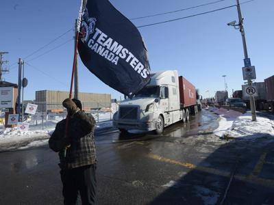 Un trabajador de Canadian Pacific Railway ondea una bandera sindical durante una huelga, el 16 de febrero de 2015, en Montreal. (Ryan Remiorz/The Canadian Press vía AP)