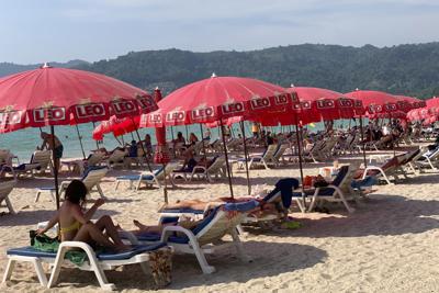 Los turistas descansan bajo sombrillas a lo largo de la playa de Patong en Phuket, Tailandia, el viernes 11 de marzo de 2022. Miles de turistas rusos están varados en los balnearios de Tailandia debido a la guerra en Ucrania, muchos de los cuales no pueden pagar sus facturas o regresar a casa debido a las sanciones y los vuelos cancelados. La crisis en Europa también puso un freno en los planes de recuperación para la industria turística de la nación del sudeste asiático, que ha recibido más visitantes de Rusia que cualquiera de sus vecinos antes de que llegara la pandemia. (AP Foto/Salinee Prab)