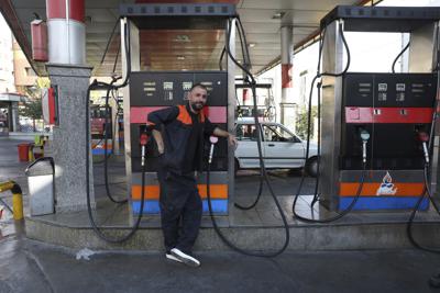 Un trabajador se apoya en una bomba de gasolina apagada en una gasolinera de Teherán, Irán, martes 26 de octubre de 2021. Las gasolineras de todo el país sufrieron un apagón de un sstema que permite a los consumidores comprar gasolina con una tarjeta emitida por el gobierno. Una agencia noticiosa semioficial dijo que se trató de un ciberataque. (AP Foto/Vahid Salemi)