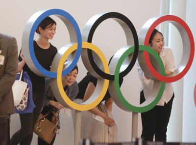 Gente posando para una foto con los anillos olímpicos en el aeropuerto internacional de Haneda, en Tokio, el jueves 8 de julio de 2021. (AP Foto/Koji Sasahara)