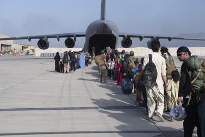 In this image provided by the U.S. Air Force, U.S. Air Force loadmasters and pilots assigned to the 816th Expeditionary Airlift Squadron, load people being evacuated from Afghanistan onto a U.S. Air Force C-17 Globemaster III at Hamid Karzai International Airport in Kabul, Afghanistan, Tuesday, Aug. 24, 2021. (Master Sgt. Donald R. Allen/U.S. Air Force via AP)