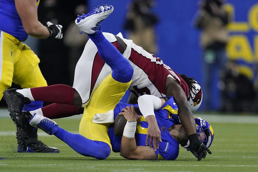 El apoyador externo de los Cardinals de Arizona, Markus Golden, arriba, captura al mariscal de campo de los Rams de Los Ángeles, Matthew Stafford, durante la primera mitad de un partido de fútbol americano de los playoffs de comodín de la NFL en Inglewood, California, el lunes 17 de enero de 2022. (Foto AP/Mark J. Terrill)