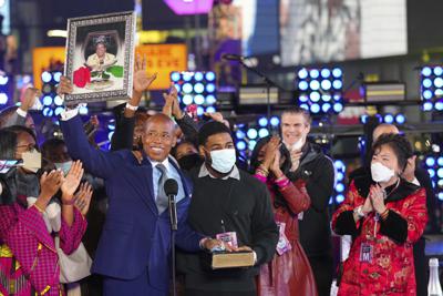 Eric Adams sostiene un cuadro con una fotografía durante su ceremonia de toma de posesión como alcalde de Nueva York, en Times Square, pasada la medianoche, el 1 de enero de 2022, en Nueva York. (Foto de Ben Hider/Invision/AP)