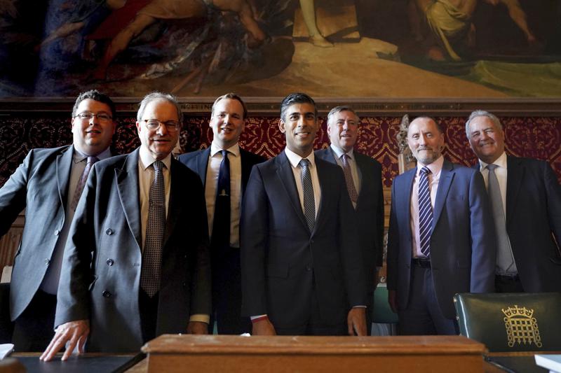 Britain's Rishi Sunak, centre, poses for a photo with members of the 1922 Committee, in the Houses of Parliament, after it was announced he will become the new leader of the Conservative party, in London, Monday, Oct. 24, 2022.  Former Treasury chief Sunak, is set to become Britain’s next prime minister after winning the Conservative leadership race. (Stefan Rousseau/PA via AP)