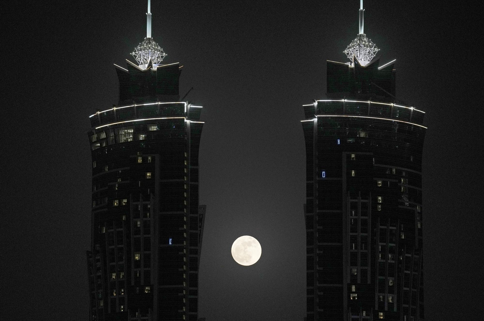 A lua cheia nasce entre duas torres, em Dubai, Emirados Árabes Unidos, terça-feira, 14 de junho de 2022. (AP Photo/Kamran Jebreili)