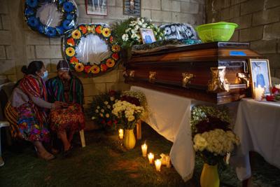 Ana Vilma Josefina Telón, segunda desde la izquierda, llora durante el velatorio de su esposo, Aurelio Cuy Tamat, en Santa Apolonia, Guatemala, el viernes 31 de diciembre de 2021. (AP Foto/Oliver de Ros)