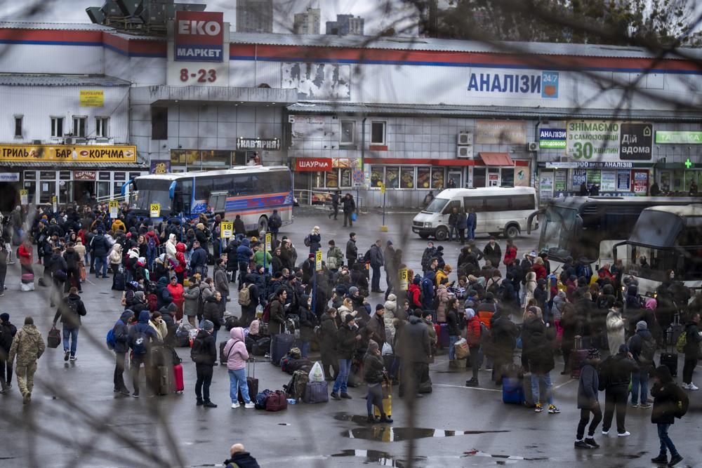 People try to get onto buses to leave Kyiv, Ukraine, Thursday, Feb. 24, 2022. (AP Photo/Emilio Morenatti)