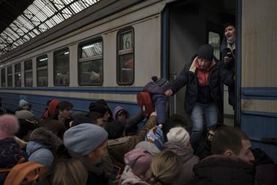 Gran cantidad de pasajeros se apresuran a abordar un tren que se dirige a Eslovaquia, el miércoles 2 de marzo de 2022, en Leópolis, Ucrania. (AP Foto/Felipe Dana)