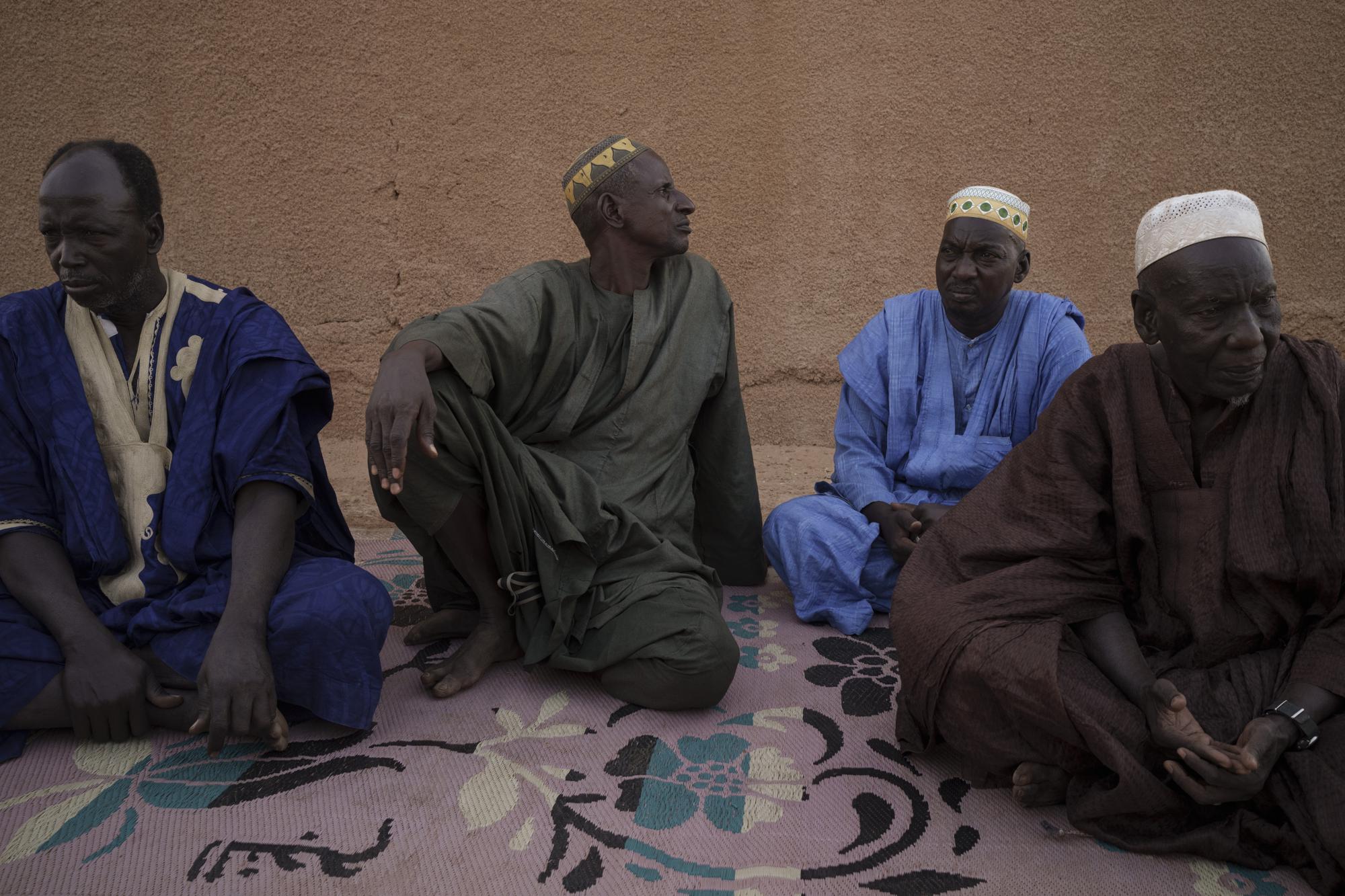 Oumar Koume, a la izquierda, sentado junto a otros familiares durante una entrevista con The Associated Press en Selibaby, Mauritania, el 7 de diciembre de 2021. El hijo de Koume, Djibi Koume, era una de las 43 personas que embarcó en una patera que fue encontrada en Tobago el 28 de mayo de 2021, más de cuatro meses después de partir desde Mauritania en un intento de llegar a las Islas Canarias, en España. (AP Foto/Felipe Dana)