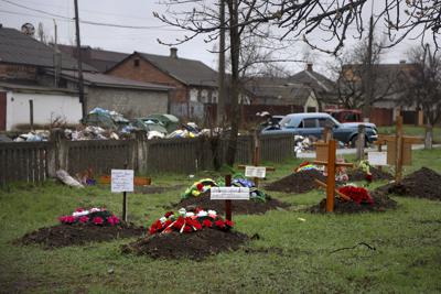Esta imagen muestra tumbas de residentes fallecidos durante la invasión rusa en un prado detrás de viviendas, el miércoles 13 de abril de 2022, en Mariúpol, Ucrania. (AP Foto/Alexei Alexandrov)