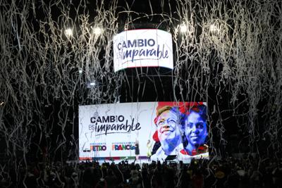 Confeti explota sobre una pantalla que muestra las fotos del candidato Gustavo Petro (izquierda), y de su compañera de fórmula, Francia Márquez, tras su victoria en el balotaje de los comicios presidenciales, en la sede de su campaña, en Bogotá, Colombia, el 19 de junio de 2022. (AP Foto/Fernando Vergara)