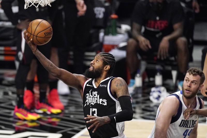 En foto del sábado 22 de mayo del 2021, el escolta de Los Clippers de Los Angeles Paul George, dispara frente a Nicolo Melli de los Mavericks de Dallas en el juego 1 de la serie de primera ronda de la postemporada. (AP Foto/Mark J. Terrill)