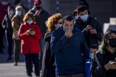 Personas con mascarillas buscan una prueba de coronavirus en el hospital de La Paz, en Madrid, el martes 28 de diciembre de 2021. (AP Foto/Manu Fernández)