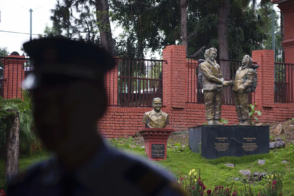 A security person stands guard in front of a statue of Tenzing Norgay and Edmund Hillary at the tourism board in Kathmandu, Nepal, Thursday, May 25, 2023. Nepal is getting ready to mark the 70th anniversary of the first ascent of Mount Everest in 1953 by New Zealander Edmund Hillary and his Sherpa guide Tenzing Norgay. (AP Photo/Niranjan Shrestha)