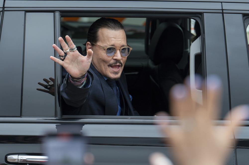 FILE - Actor Johnny Depp waves to supporters as he departs the Fairfax County Courthouse during his high-profile libel lawsuit against ex-wife Amber Heard, on May 27, 2022 in Fairfax, Va. (AP Photo/Craig Hudson, File)