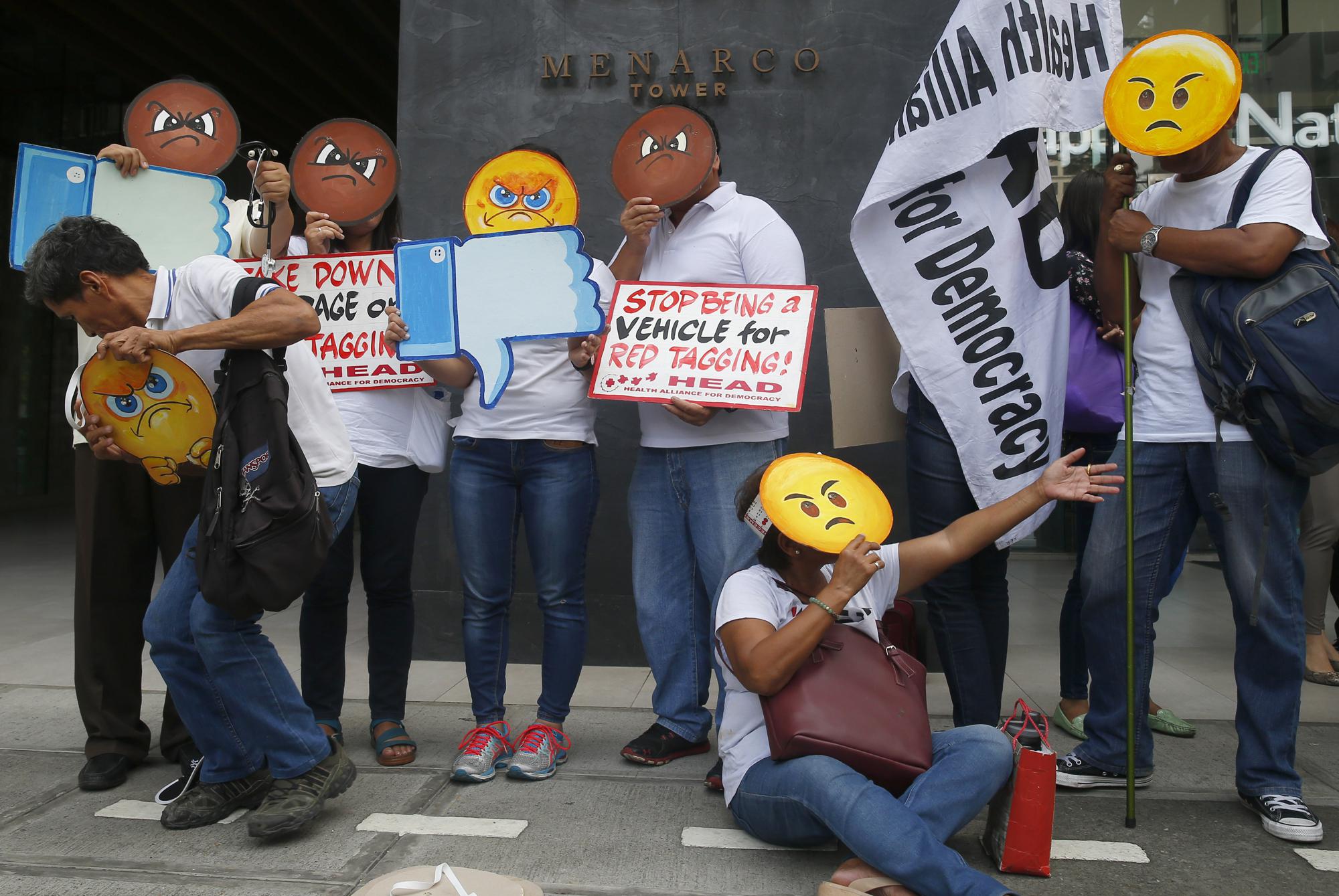 FILE – In this May 9, 2019, file photo, protesters, wearing "angry emoticon" masks picket the Facebook office in the country to protest Facebook's alleged inaction against fake news, hate speech and red-tagging or vilification campaign of health activists, in suburban Taguig city east of Manila, Philippines. From complaints whistleblower Frances Haugen has filed with the SEC, along with redacted internal documents obtained by The Associated Press, the picture of the mighty Facebook that emerges is of a troubled, internally conflicted company, where data on the harms it causes is abundant, but solutions are halting at best. (AP Photo/Bullit Marquez, File)