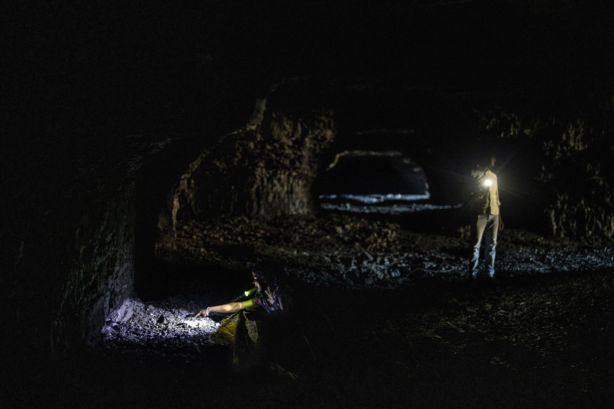 A young woman holds a torch in her mouth as she collects coal from a mine near Dhanbad, an eastern Indian city in Jharkhand state, Friday, Sept. 24, 2021. A 2021 Indian government study found that Jharkhand state -- among the poorest in India and the state with the nation’s largest coal reserves -- is also the most vulnerable Indian state to climate change. Efforts to fight climate change are being held back in part because coal, the biggest single source of climate-changing gases, provides cheap electricity and supports millions of jobs. It's one of the dilemmas facing world leaders gathered in Glasgow, Scotland this week in an attempt to stave off the worst effects of climate change. (AP Photo/Altaf Qadri)