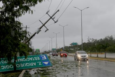 Un letrero derribado por los vientos del huracán Grace queda a un costado de la autopista, el jueves 19 de agosto de 2021, en Tulum, en el estado de Quintana Roo, México. (AP Foto/Marco Ugarte)