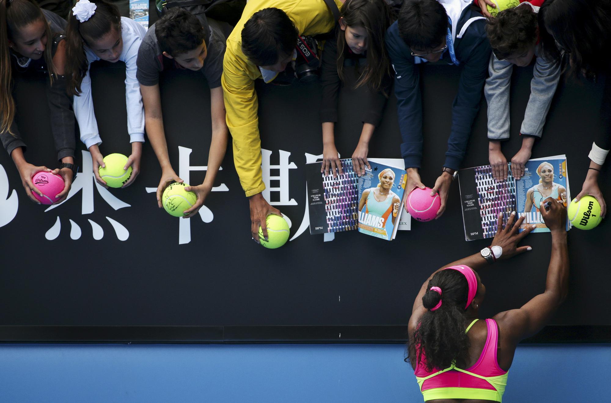 FILE - Serena Williams of the U.S. signs autographs for fans after defeating Garbine Muguruza of Spain in their fourth round match at the Australian Open tennis championship in Melbourne, Australia, Monday, Jan. 26, 2015. After nearly three decades in the public eye, few can match Serena Williams' array of accomplishments, medals and awards. Through it all, the 23-time Grand Slam title winner hasn't let the public forget that she's a Black American woman who embraces her responsibility as a beacon for her people. (AP Photo/Rob Griffith, File)