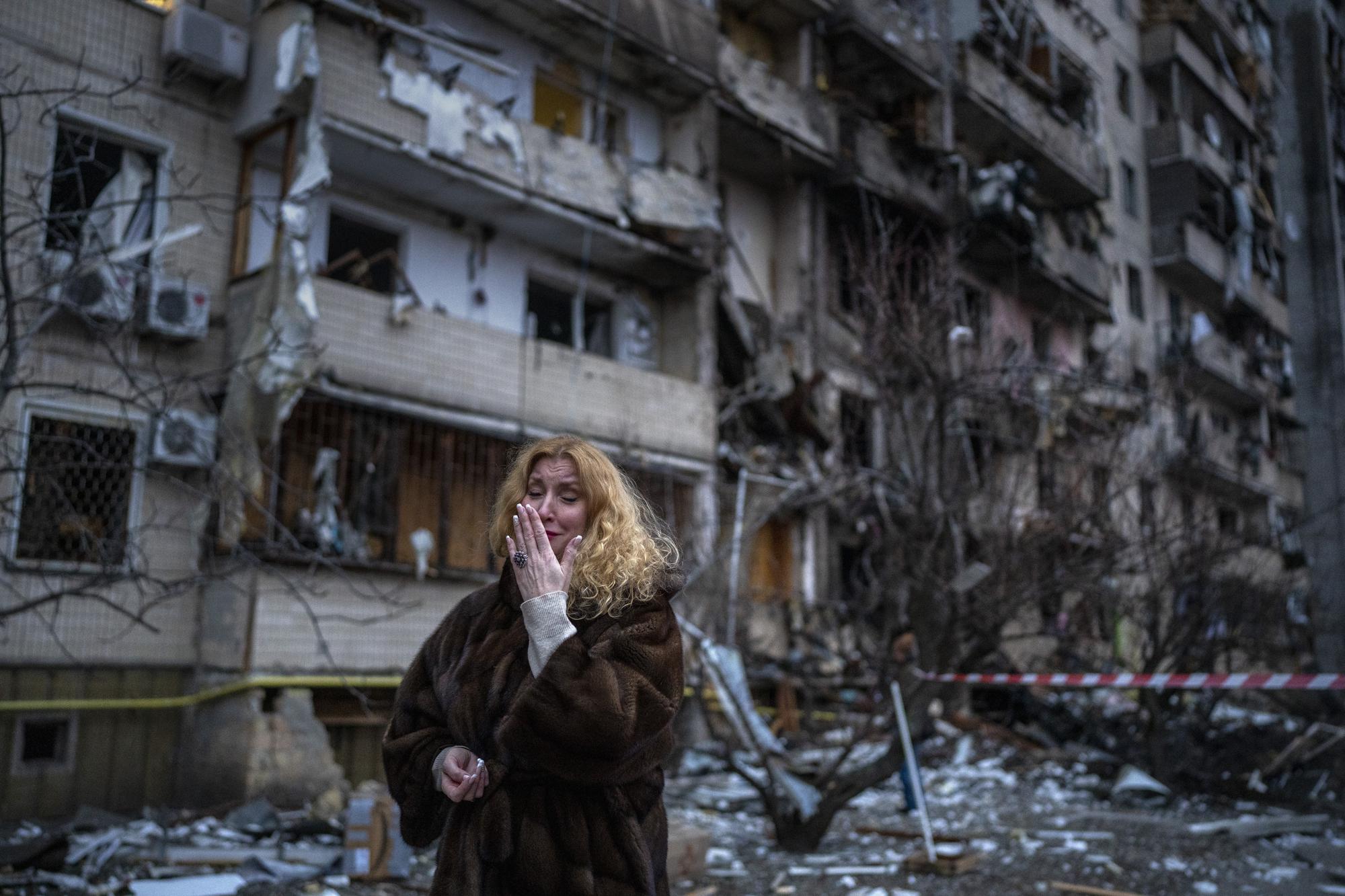 Natali Sevriukova llora frente al edificio que fue su hogar luego de un ataque con cohetes en Kyiv, Ucrania, el 25 de febrero de 2022. (Foto AP/Emilio Morenatti)