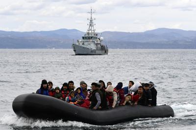 Archivo - Migrantes en una lancha neumática escoltada por una nave de Frontex arriban a la aldea costera de Skala Sikaminias, en la isla griega de Lesbos, el 28 de febrero de 2020. (AP Foto/Michael Varaklas, Archivo)
