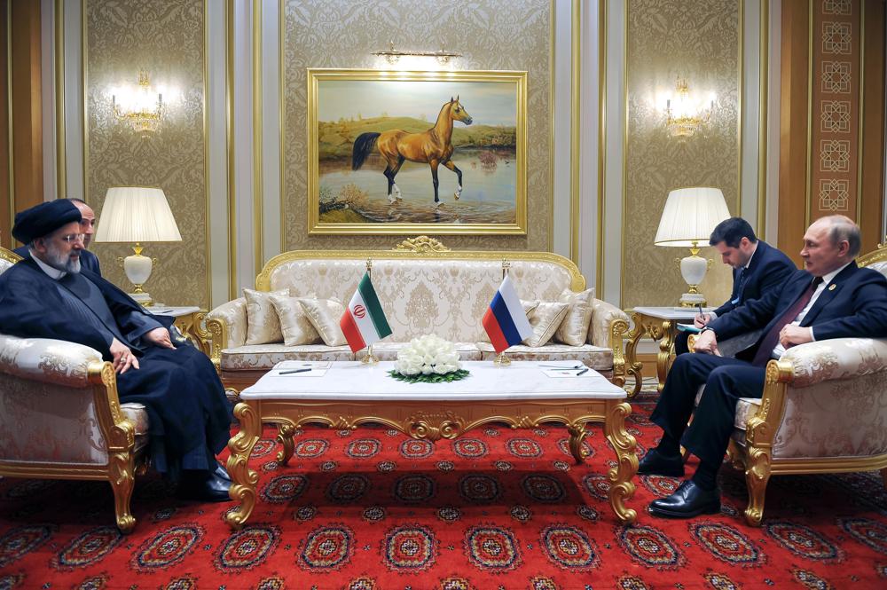 FILE - Russian President Vladimir Putin, right, speaks to Iran's President Ebrahim Raisi on the sideline of the summit of Caspian Sea littoral states in Ashgabat, Turkmenistan, on June 29, 2022. Putin's visit to Iran starting Tuesday, July 19, is intended to deepen ties with regional heavyweights as part of Moscow's challenge to the United States and Europe amid its grinding campaign in Ukraine. (Mikhail Klimentyev, Sputnik, Kremlin Pool Photo via AP, File)