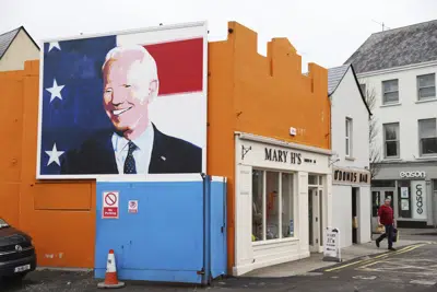 Un mural del presidente Joe Biden en el costado de una tienda en Ballina, Irlanda, el martes 4 de abril de 2023. La emoción está aumentando en Ballina, un pequeño pueblo irlandés que fue el hogar de algunos de los antepasados del presidente estadounidense Joe Biden, quien tiene previsto visitarlo la semana próxima como parte de un viaje de cuatro días a Irlanda y la vecina Irlanda del Norte. (AP Foto/Peter Morrison)